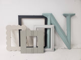 A mix and match set of vintage, shades of gray picture frames for a gallery wall, Assorted grey ombre photo frame wall collage for family memories